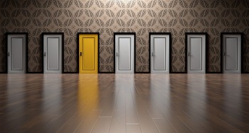 Row of white doors with one yellow door